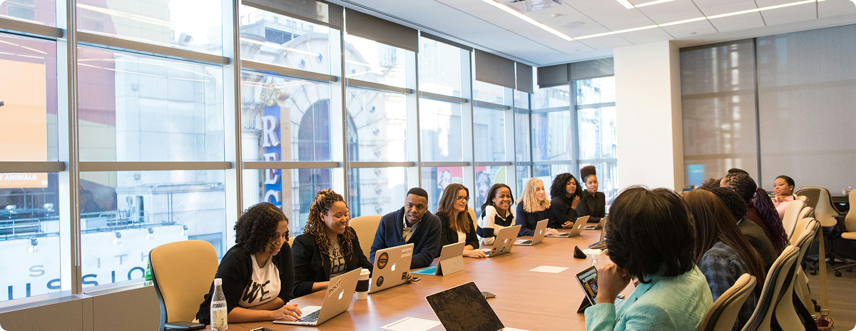 Team collaborating around a conference table with laptops